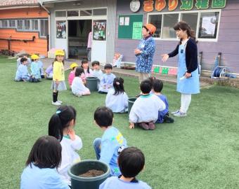 Niños y niñas víctimas del terremoto en la nueva guardería católica de Sayuri plantando semillas de tomate.

