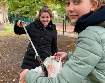 Estudiantes limpiando el jardín del colegio
